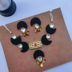 This black fabric and Kundan necklace set is a modern choice for a wedding reception or sangeet. The half-moon fabric pieces are paired with a central Kundan pendant and matching earrings.