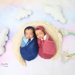 Dreaming on a rainbow. These two little ones are swaddled and sleeping together under a pastel rainbow, symbolizing the joy and hope they bring.