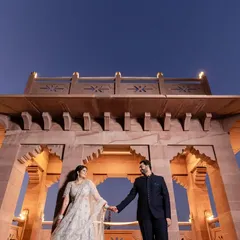 Framing your love against the grandeur of history. This shot, taken at dusk at a heritage hotel in Jodhpur, uses architectural lines and dramatic low-angle composition to create a sense of timeless, regal romance.