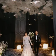 The grand entrance is a cinematic moment, and I capture it with the drama it deserves. Here, the couple makes their way into the reception under a stunning ceiling installation of white doves, setting a magical tone for the evening.