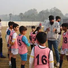 A coach gathers his team for a quick talk during a league game. These moments of guidance are crucial for player development and team cohesion.