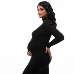 A classic profile silhouette in the black dress. This pose is perfect for showcasing the beautiful curve of the baby bump in a simple and elegant way.