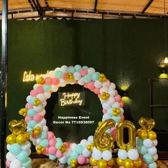 This semi-circle balloon arch was designed for a 60th birthday party. The pastel colors and gold accents, along with the large foil numbers, create a cheerful and celebratory photo backdrop.