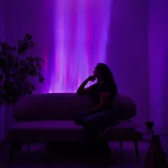 A single light fixture creating a captivating aurora effect. This image showcases how our dynamic color-changing lights can be used to paint your walls with light, turning a simple room into an immersive, atmospheric space for relaxation or entertainment.