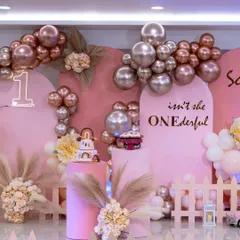 A truly "ONEderful" first birthday for a little princess. The combination of pink backdrops, a custom neon sign, and a cascade of metallic and pastel balloons makes for a stunning photo opportunity and a magical party atmosphere.