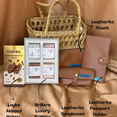 This hamper is designed for pure relaxation and style. It features a reusable cane basket filled with a leatherite passport holder and sunglasses pouch, a luxurious bathing bar set, and a box of rich almond brittle. It's a perfect wellness and travel kit for corporate or personal gifting.