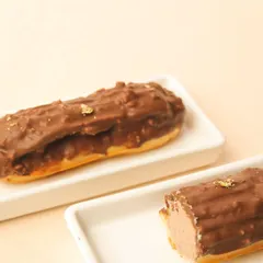 A close-up of our Rocher eclair, filled with a rich hazelnut cream and coated in chocolate with crunchy nuts.