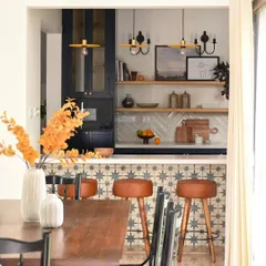 This view from the dining area shows how the breakfast bar creates a social, open connection to the kitchen. The warm leather stools and pendant lights make it an inviting spot, while the open shelves inside can be dressed up as a bar for entertaining.