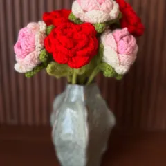 A beautiful bouquet of handmade crochet roses in red and pink, arranged in a modern vase. They add a touch of romance and elegance to any space.