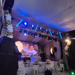 This angle shows the full stage setup, including the balloon arch decorations on the sides. The combination of simple decor elements with high-tech lighting allows for a versatile look suitable for many types of social events.