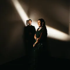 A dramatic and artistic portrait from a Sangeet night. Using a single beam of light, I highlighted the bride in her stunning green outfit while the groom stands in the shadows, creating a moody and cinematic couple photograph.