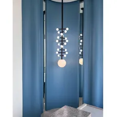 Another angle of the statement light, showing how it interacts with the curved blue walls and the reflection in the mirror.