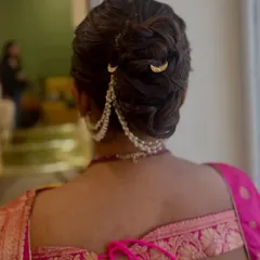 This elegant braided bun is adorned with a beautiful pearl hair chain and delicate moon-shaped pins. It's a perfect example of how traditional elements can be styled in a modern and sophisticated way.