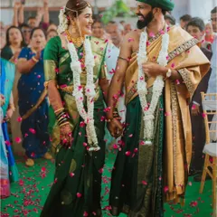The couple walks hand-in-hand down the aisle, surrounded by family and a shower of petals, in a beautiful South Indian ceremony.
