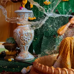An action shot capturing the exact moment of the celebratory water splash during a traditional Haldi. These high-energy photos freeze a moment of pure fun.