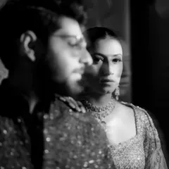 An artistic and moody monochrome portrait, using creative focus to draw attention to the bride's intense gaze.