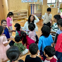 A teacher sits on the floor with the children during a pet visit, creating a circle of warmth and curiosity. Our mentors guide children to interact gently and respectfully with animals.