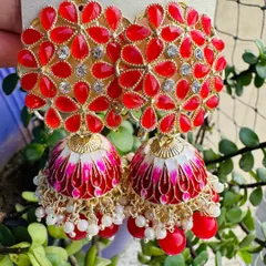 A classic combination of red and gold. These jhumkas feature red enamel work on a floral stud and dome, accented with small pearls for a traditional yet stylish feel.