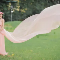 A classic portrait featuring one of my popular flying trail gowns. The soft pink fabric and the outdoor setting create a dreamy, ethereal look that celebrates your journey to motherhood.