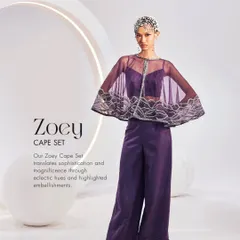 The Zoey Cape Set in a regal purple. This ensemble features a sheer embellished cape paired with a simple bustier and wide-leg trousers for a look of magnificent sophistication.