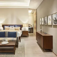 The master bedroom in the Max128 apartment is a study in tranquility. We used a palette of soft beiges and regal blues, with curated art and warm wood furniture to create a serene and personal sanctuary.