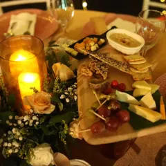 A gourmet grazing board serving as a centerpiece. This arrangement of assorted cheeses, crackers, nuts, fruits, and hummus offers a delicious and visually appealing appetizer for guests to share.