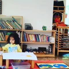 A young child works on a puzzle map of the world. After completing the puzzle, she will trace the continents and paint them, extending a simple geography lesson into a multi-step art project.