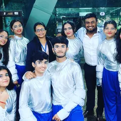A picture with a group of boys and girls in their silver and blue costumes, showcasing another one of the diverse acts from the school festival.