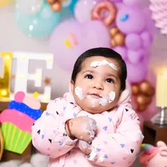 A quiet moment of contemplation amidst the cake chaos. Even the thoughtful expressions are priceless memories from a first birthday shoot.