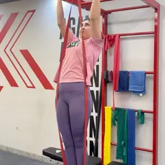 Rebuilding strength is a critical step in neck injury rehabilitation. Here, our patient performs assisted pull-ups with resistance bands, a key exercise to safely strengthen the muscles supporting her neck and upper back.