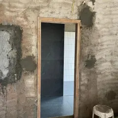A doorway during construction, with freshly plastered walls meeting new tile work. This image captures the intersection of raw materials and finished surfaces, a pivotal moment in the journey of giving a space a new lease on life.