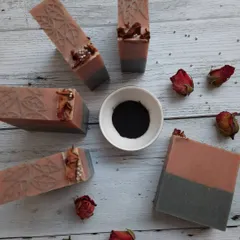 This is my Charcoal Rose soap, a customer favorite. I arrange each bar with dried rosebuds and a sprinkle of charcoal powder, showcasing the natural French pink clay and activated charcoal that work to gently detoxify your skin.