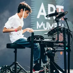 A close-up of our student drummer, completely focused during the Art Mumbai festival. Learning drums with us helps build rhythm, coordination, and the confidence to perform for a large audience.