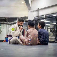 Mentorship is at the heart of what we do. Here, Coach Shaun takes the time to connect with our youngest students, explaining concepts and building the trust that is essential for real growth on and off the mats.