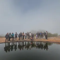 A stunning group photo of college students with their reflection in a clear mountain pool. These treks offer unique opportunities for both adventure and creative photography.