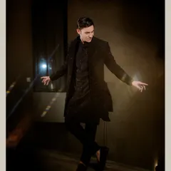 A dynamic and stylish portrait of the groom, captured mid-pose during his Sangeet night.