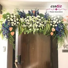 An elegant floral arch over a main door. This design features a sophisticated mix of blue orchids, white lilies, and lush greenery, creating a luxurious welcome.