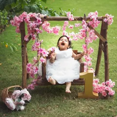 A big, joyful laugh on a floral swing. This outdoor first birthday shoot is full of fresh air, flowers, and happiness.