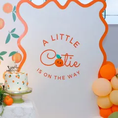 A close-up of the adorable "A Little Cutie is on the Way" sign and matching cake, perfectly capturing the fresh and sweet theme of the baby shower.