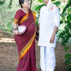 A beautiful portrait of a couple in traditional Indian attire for their maternity shoot. The mother-to-be looks radiant in her checkered saree, capturing a blend of cultural heritage and anticipation.