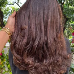 The back view of a fresh layered cut, styled with a bouncy blowout. You can see how the layers add shape and remove weight, creating a beautiful cascade effect.