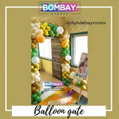 A balloon gate is a fantastic way to welcome guests to a party. For this event, we created a jungle-themed balloon arch using shades of green, gold, and white, with animal-print accent balloons.