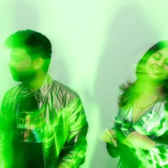 A cool, edgy portrait using green light to create a vibrant and modern effect. The couple's relaxed poses and the motion blur give this shot a dynamic, high-fashion vibe.