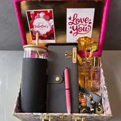 A stylish and practical gift set for her, presented in a beautiful suitcase-style box. This hamper includes a personalized tumbler, diary, pen, and keychain, along with a golden rose and perfume.