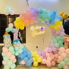 A gorgeous pastel rainbow balloon arch for a "Baby Shower." This design uses a soft and dreamy color palette and a neon sign to create a magical photo backdrop.