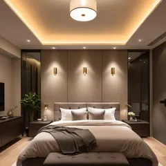 This bedroom achieves a warm and inviting atmosphere with a layered lighting design, including cove lighting in the false ceiling and focused wall sconces. The neutral color palette and plush furnishings create a perfect sanctuary for relaxation.