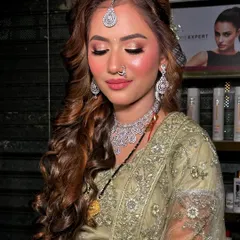This reception look is all about confidence. The soft curls, glowing skin, and defined eyes come together for a look that is both glamorous and sophisticated.