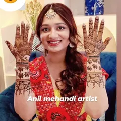 A smiling bride-to-be proudly displaying her beautiful mehandi. The design features lotus bands on the wrists and delicate patterns on the hands.