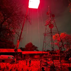 A wider shot of the red-lit moonbox rig for 'Kishkindhapuri'. This view shows the crane and support structures required for such a large-scale outdoor lighting effect.