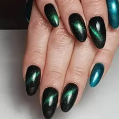 A gorgeous green cat-eye manicure. The deep emerald base with the bright green magnetic shimmer creates a look that is both mysterious and luxurious.